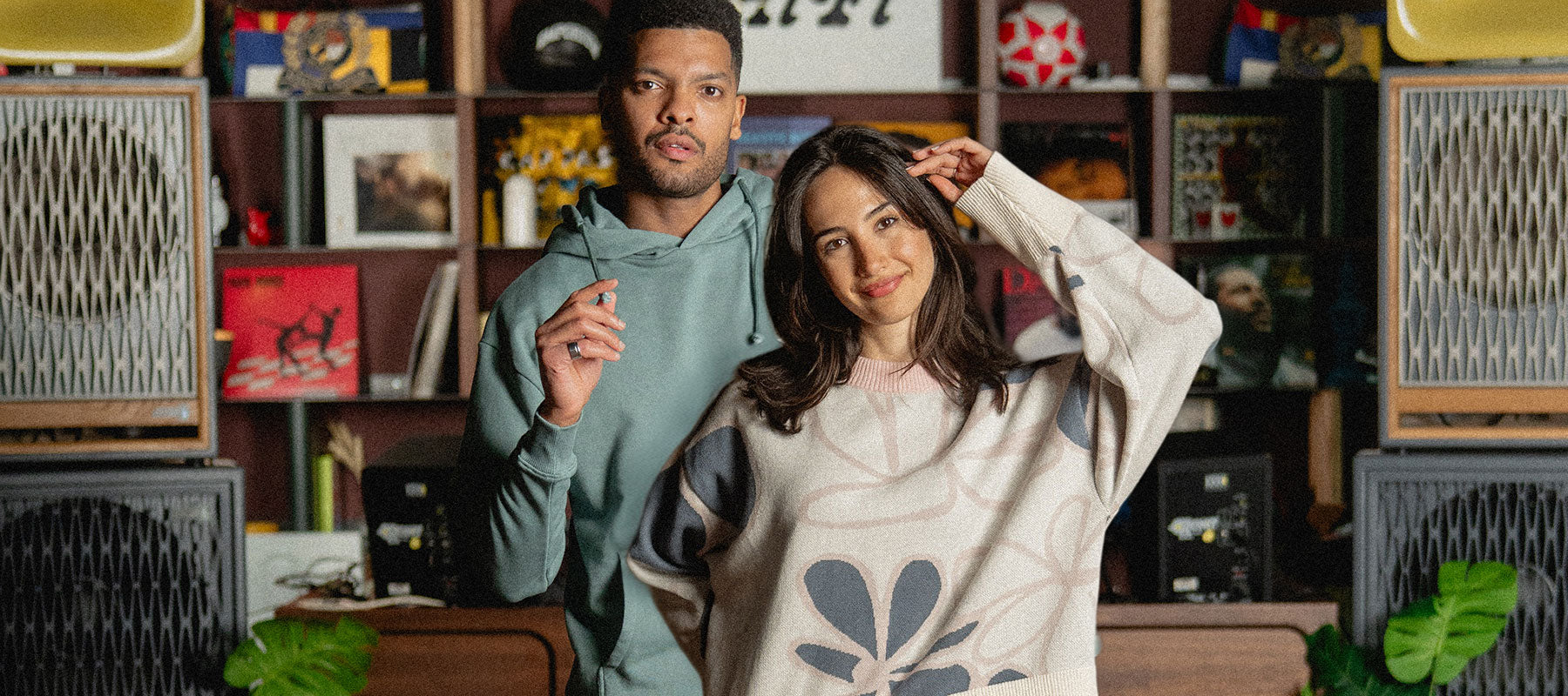 Two people wearing a Hoodie and a Knit Jumper in a room with vintage electronic equipment.